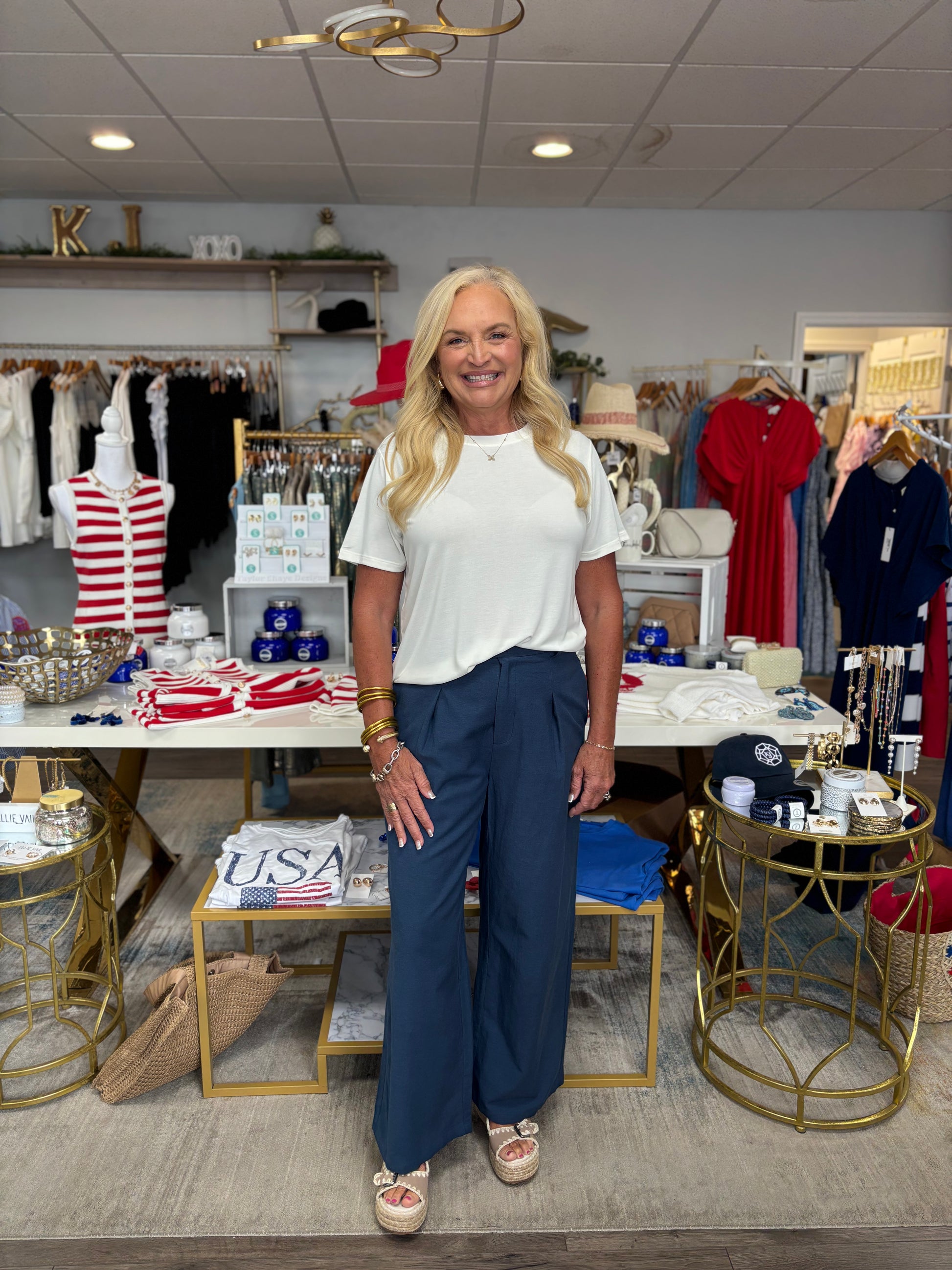 Woman standing in a store with various products and decor around her