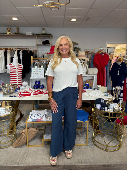 Woman standing in a store with various products and decor around her