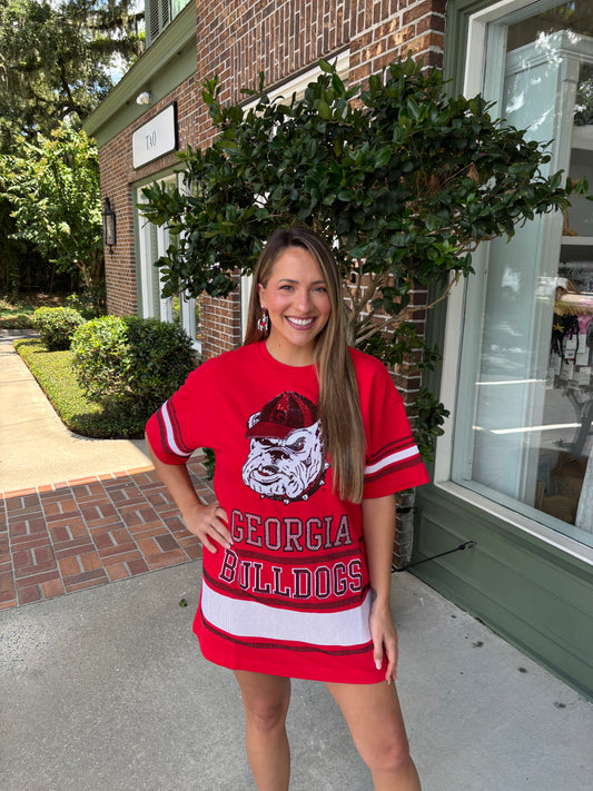 Woman wearing a red 'Georgia Bulldogs' shirt standing outside a building.