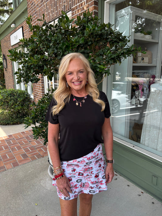 Woman standing outside a building with a brick facade and green door.