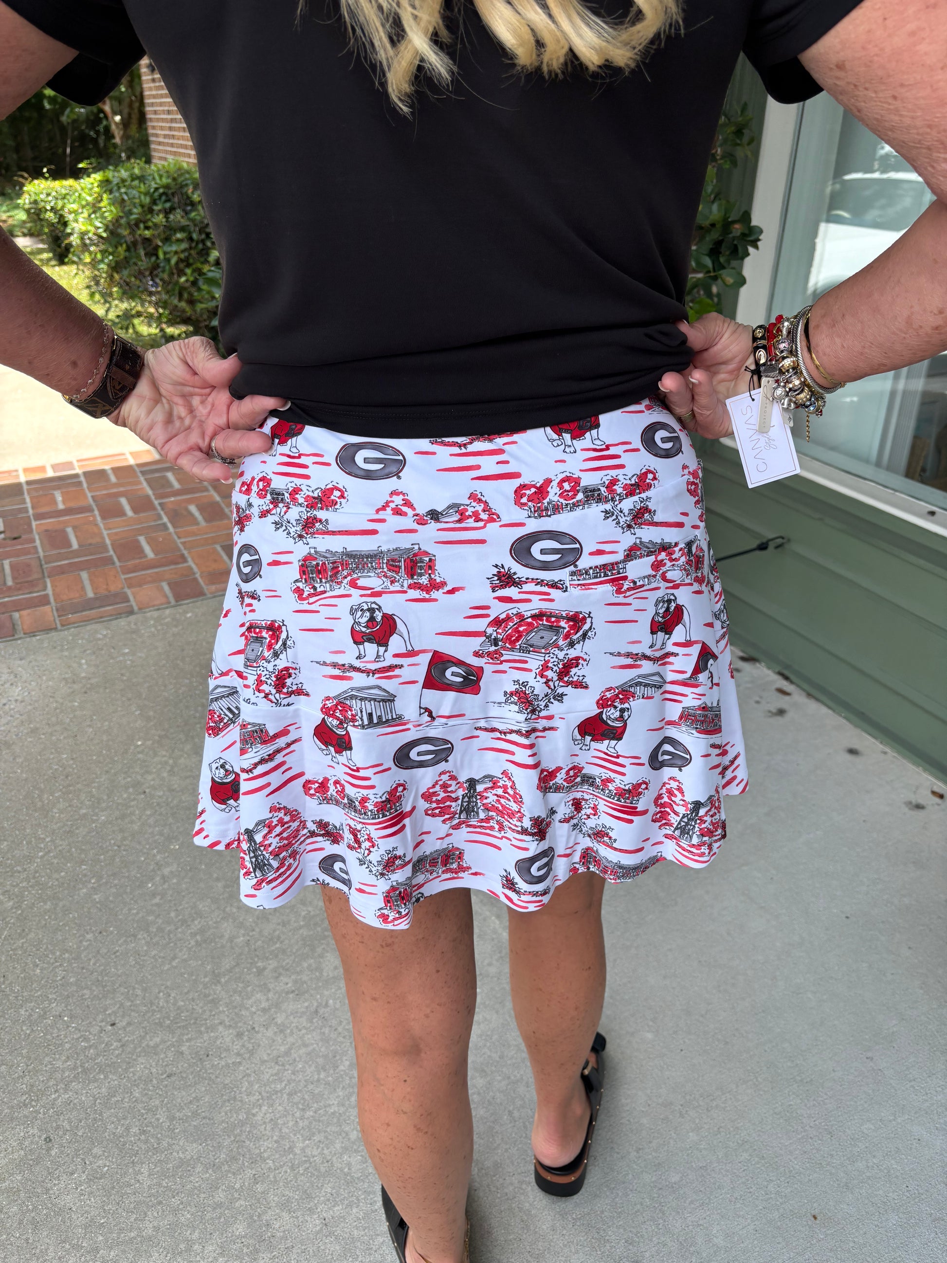 Person wearing a patterned skirt with visible branding outdoors.