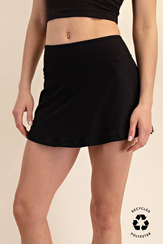 Black skirt worn by a person on a beige background with 'Recycled Polyester' label.
