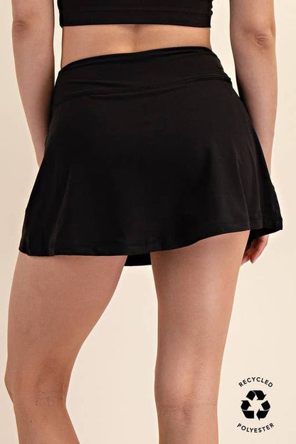 Black skirt worn by a person on a beige background with a recycled polyester label.